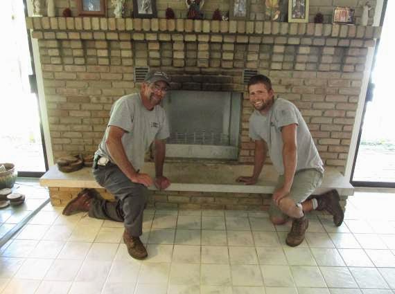 Men posing by restored fireplace