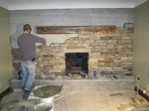 New Stone Masonry Fireplace Install with tech working on masonry with stone.  The whole wall with be the fireplace.