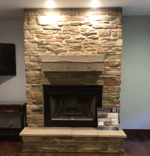 Fireplace Makeover - Irregular stone surround with two slab mantel and black firebox. Hearth is made of small slabs of limestone with samples of stone to the right.