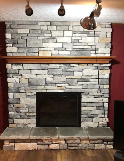 Fireplace makeover- new grey stone surround with wood mantelpiece